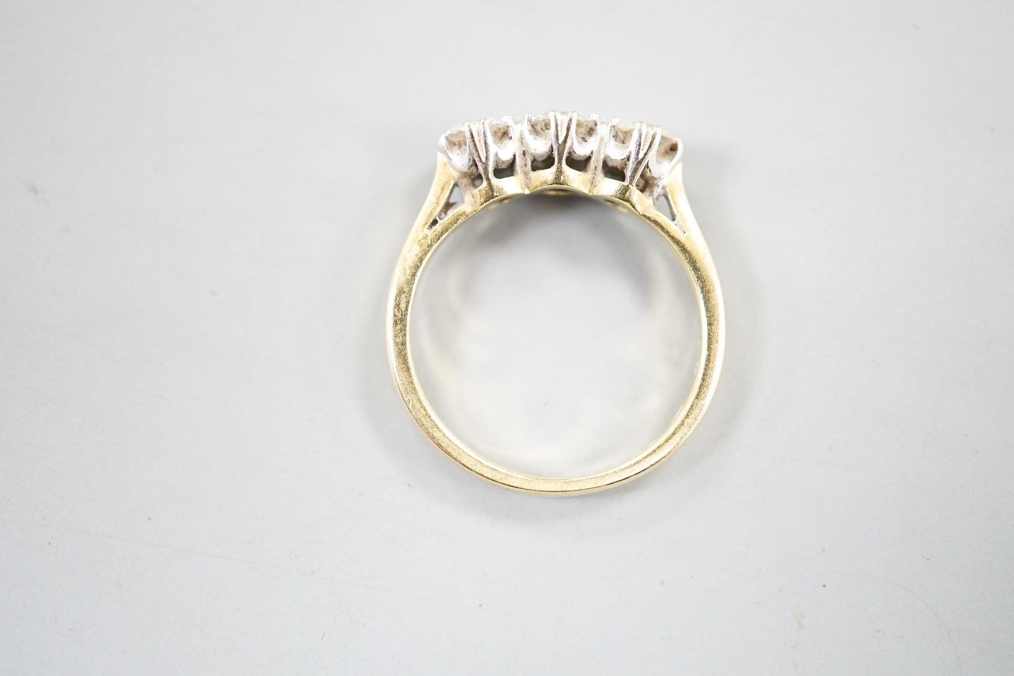 A modern 18ct gold and three stone diamond set ring, size J, gross weight 3 grams.